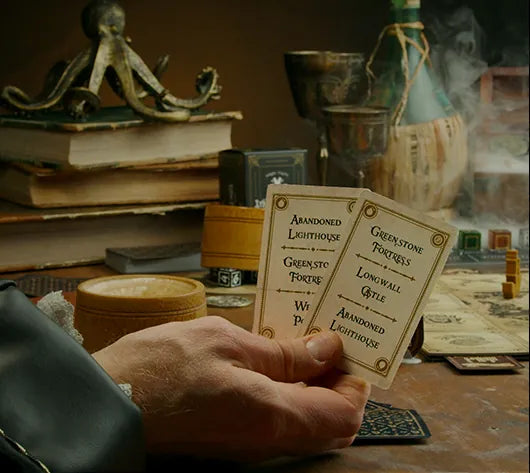 A hand holding two Influence cards over the game table